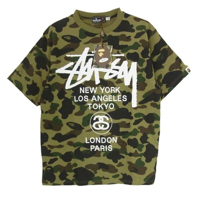 A BATHING APE アベイシングエイプ Tシャツ × STUSSY ステューシー 30周年記念 ワールドツアー ロゴ カモ柄 半袖 カットソー Tシャツ カーキ系 M【新古品】【未使用】【中古】