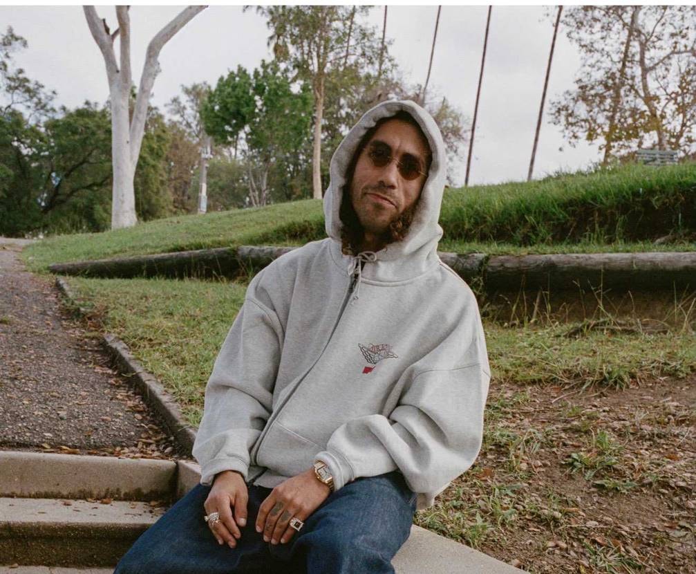 このグレーのジップアップフーディーはどこで販売されるの？